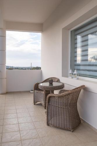 a patio with a table and chairs and a window at Villa Campagna in Kefalos