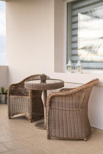 a wicker table and two chairs sitting next to a window at Villa Campagna in Kefalos