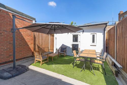 a patio with a table and chairs and an umbrella at Modern Studio Central Location Private Bathroom and shared Kitchen 2 in Edgware