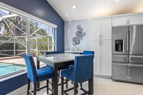 a kitchen with a dining room table and blue chairs at Modern 4BR in Central Wellington- Walk to Shops in Wellington