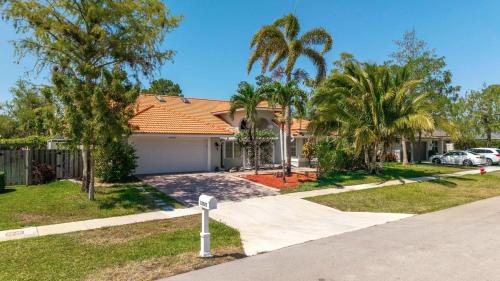 a house with palm trees and a driveway at Modern 4BR in Central Wellington- Walk to Shops in Wellington
