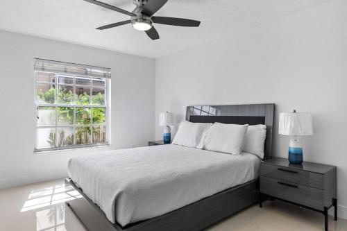 a white bedroom with a bed and a ceiling fan at Modern 4BR in Central Wellington- Walk to Shops in Wellington