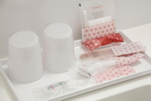 a shelf with two cups and other items in a refrigerator at Hotel Togariishi in Chino