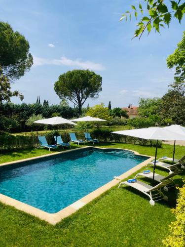 - une piscine avec des chaises longues et des parasols dans l'établissement La Bastide de Villecroze, à Villecroze