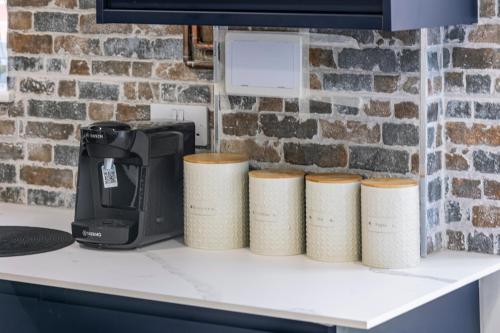 a kitchen counter with a coffee maker and four rolls of paper towels at Bespoke Studio 23 Min - C London Private Bathrroom Shared Kitchen 3 in Edgware