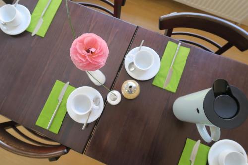 a wooden table with a pink flower on top of it at Hotel an der Marienkirche in Lübeck
