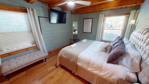 a bedroom with a white bed and two windows at Tucked Away on the Ridge - Quiet Fall Lake Retreat in Cadiz