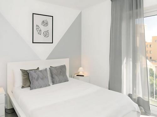 a white bedroom with a white bed and a window at Alegria 79 - Fabulous 3 Bedroom House in Coimbra