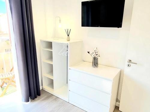 a white cabinet with a tv on a wall at Alegria 79 - Fabulous 3 Bedroom House in Coimbra