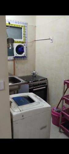 a small kitchen with a stove and a sink at وحدة للإيجار في إحدى قرى الساحل الشمالي المميزة in Dawwār Abū Maḩrūs