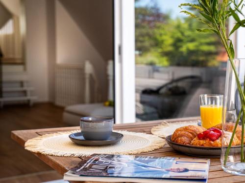 a table with a plate of food and a cup of orange juice at Das Torhaus in Lübeck
