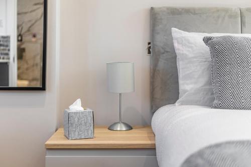 a bed with a night stand with a lamp on it at Studio at Tube Station Sleeps 3 Private Bathroom shared Kitchen 4 in Edgware