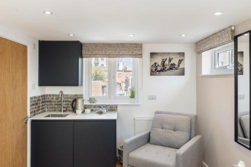 a kitchen with a chair and a sink at Studio at Tube Station Sleeps 3 Private Bathroom shared Kitchen 4 in Edgware