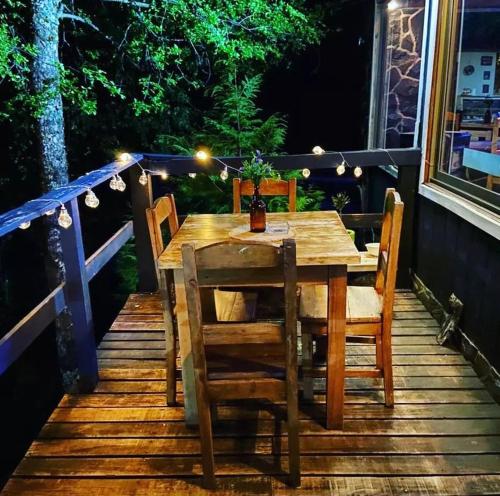 a wooden table and chairs on a deck with lights at HOTEL BOUTIQUE ANTTUY - Snow Spa in Chillán