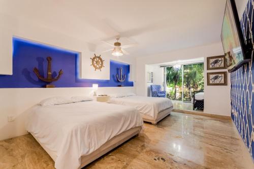 two beds in a bedroom with blue and white walls at Tropical 3 BDR Villa with pool By Casa Paraíso in Cancún