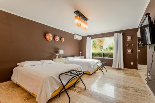 a bedroom with two beds and a television in it at Tropical 3 BDR Villa with pool By Casa Paraíso in Cancún