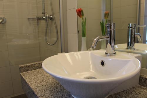 a white sink in a bathroom with a shower at Bed & Breakfast Hotel Müllerhof in Caputh