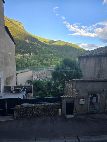 une vue d'un bâtiment avec une montagne en arrière-plan dans l'établissement L' instant cosy climatisé, à Sisteron
