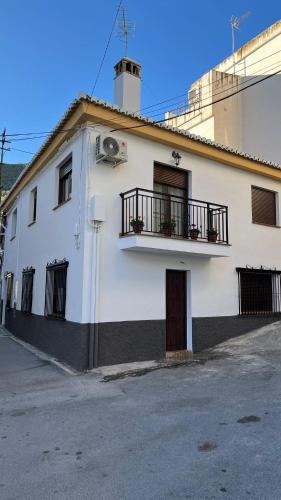 a white building with a balcony on the side of it at Encarnita Apartamento - Monachil in Monachil