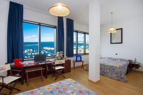 sypialnia z biurkiem i komputerem oraz pokój z oknami w obiekcie Hotel Bellavista Club-Caroli Hotels w mieście Gallipoli