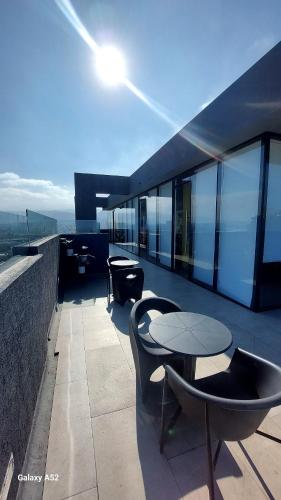 a balcony with tables and chairs on a building at Increíble Departamento Studio - Centro Antofagasta in Antofagasta
