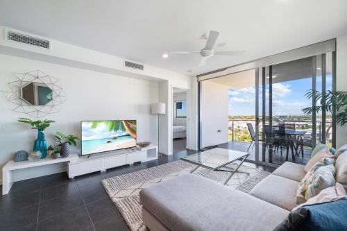 a living room with a couch and a tv at Salt at Oceanside in Kawana Waters