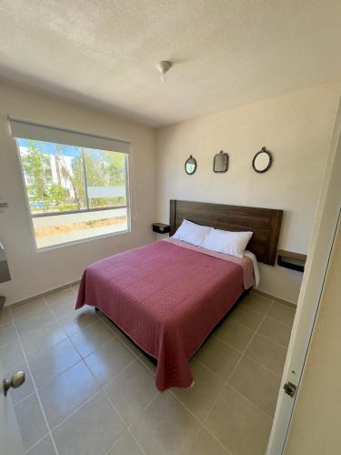 a bedroom with a large bed and a window at Linda casa frente a alberca en Playa del Carmen in Playa del Carmen