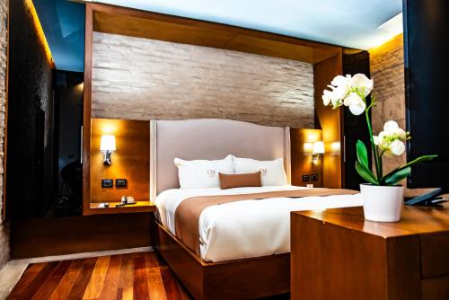 a hotel room with a large bed and a desk at Hotel Boutique Casa Madero in Morelia