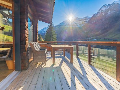 a wooden deck with a table and bench on a balcony at Spykerhütte in Rauris