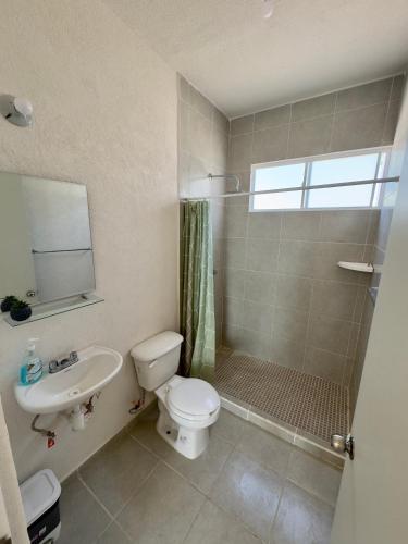 a bathroom with a shower and a toilet and a sink at Linda casa frente a alberca en Playa del Carmen in Playa del Carmen