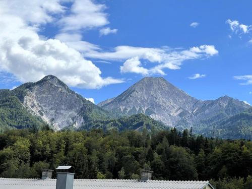 a view of mountains with trees and a house at Residenz Aichwaldsee in Unteraichwald