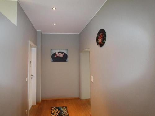 an empty hallway with a clock on the wall at Residenz Aichwaldsee in Unteraichwald