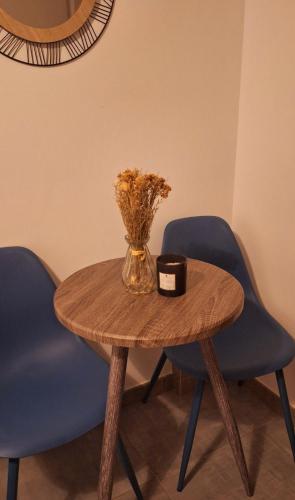une table avec un vase de fleurs et deux chaises dans l'établissement Chambre Indépendante avec Salle de Bain et Parking Gratuit, à Pelousey