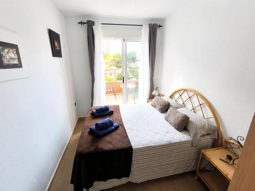 Un dormitorio con una cama con dos toallas azules encima. en Habitación Cabo Huertas, en Alicante