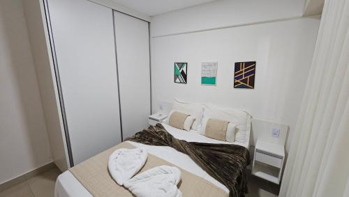 two beds in a white room with towels on them at Flat Lindíssimo de 2qts uma esquina do Flamboyant Shopping 206 in Goiânia