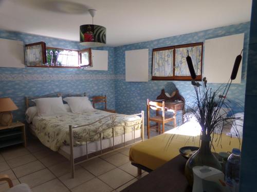 a bedroom with a bed and a table and chairs at La Chambre du Bout du Monde in Bouillac