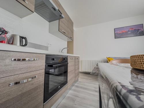 a kitchen with a stove and a counter top at Le Dunant - Rocade - Tram in Grenoble
