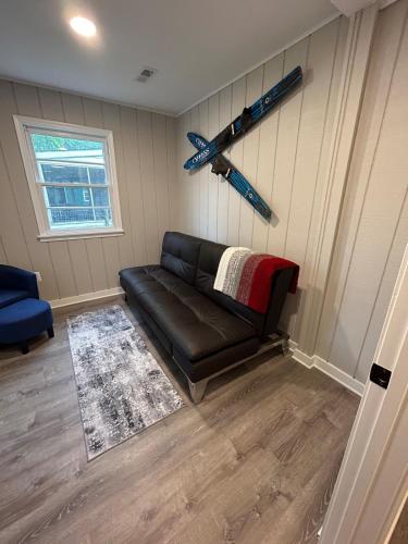 a living room with a black leather couch and a window at Rivers Edge - On the River, Breathtaking views! in Front Royal