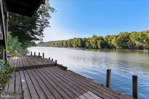 a wooden dock on a lake with trees in the background at Rivers Edge - On the River, Breathtaking views! in Front Royal