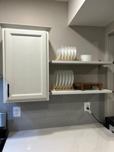 a kitchen with white cabinets and plates on shelves at Rivers Edge - On the River, Breathtaking views! in Front Royal