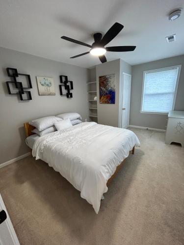 a bedroom with a large bed with a ceiling fan at Rivers Edge - On the River, Breathtaking views! in Front Royal