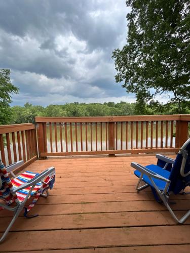 two lawn chairs sitting on a deck with trees in the background at Rivers Edge - On the River, Breathtaking views! in Front Royal