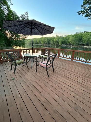 a table and bench on a deck with an umbrella at Rivers Edge - On the River, Breathtaking views! in Front Royal