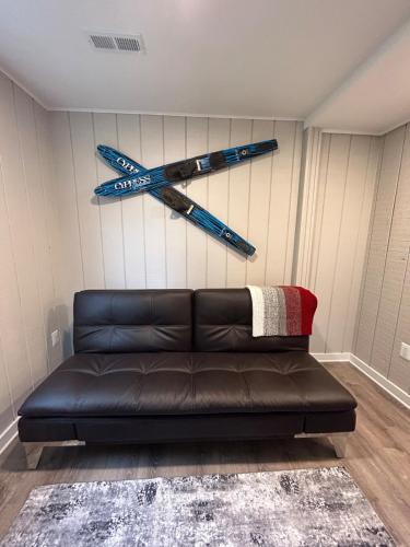 a black leather couch in a room with a cross on the wall at Rivers Edge - On the River, Breathtaking views! in Front Royal