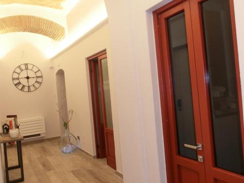 a hallway with a red door and a clock on the wall at Agua B'n'B in Grosseto