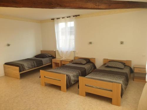 una stanza con tre letti e una finestra di Gîte de charme près du lac du Der avec jardin clos, 4 chambres, parking privé, et équipements modernes - FR-1-611-13 a Valcourt