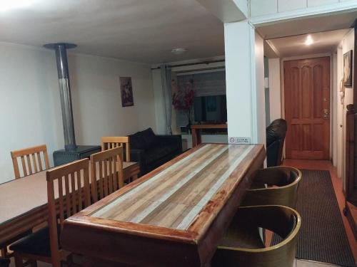 een woonkamer met een houten tafel en stoelen bij Alquiler House in Puerto Montt