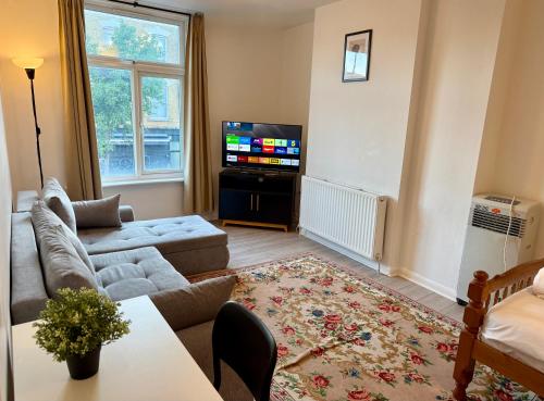 a living room with a couch and a tv at Enormous Family Flat (7 guests) in London