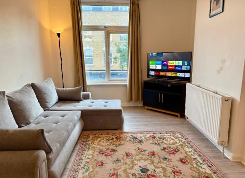 a living room with a couch and a flat screen tv at Enormous Family Flat (7 guests) in London