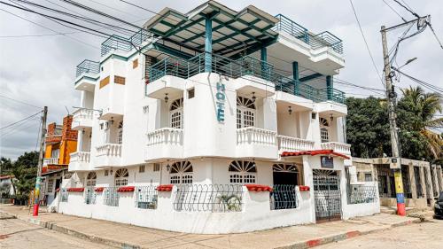 a white building with a balcony on a street at Hotel Santiago de Tolú in Santiago
